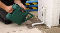 Watering can with warm water used to thaw a condensate pipe.